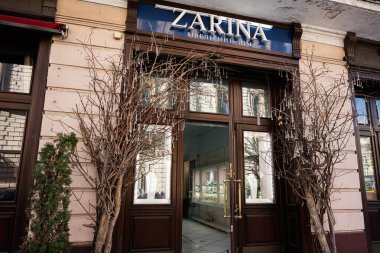 Lviv, Ukrayna - Nisan 06, 2025: Dekoratif ağaçların ve şık mimarinin yer aldığı bir kuyumcunun Zarina mağazasının güzel vitrini 