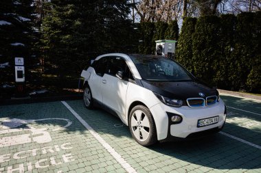 Lviv, Ukrayna - Nisan 06, 2025: Çevre dostu BMW i3 elektrikli araba halka açık bir şarj istasyonunda takıldı