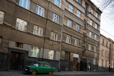 Lviv, Ukrayna - Nisan 06, 2025: Eski yeşil bir Moskvitch 412 arabası şehrin caddesinde eski bir binanın yakınına park edilmiş..