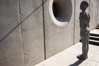 Lviv, Ukrayna - Nisan 06, 2025: Modern bir duvarın yanında dairesel açıklığı olan beton bir Zenyk Sanat Galerisi heykeli. 
