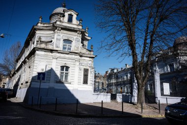 Lviv, Ukrayna - Nisan 06, 2025: Lviv, Ukrayna 'da sakin bir sokakla çevrili açık mavi gökyüzünün altındaki beyaz tarihi bina. Semenskyi-Levytskyi Sarayı. 