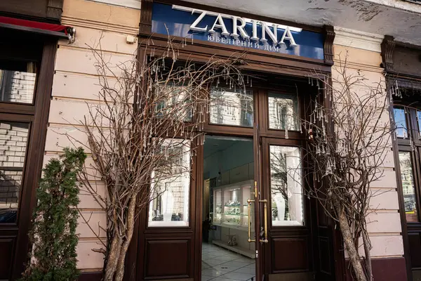 Lviv, Ukrayna - Nisan 06, 2025: Dekoratif ağaçların ve şık mimarinin yer aldığı bir kuyumcunun Zarina mağazasının güzel vitrini 