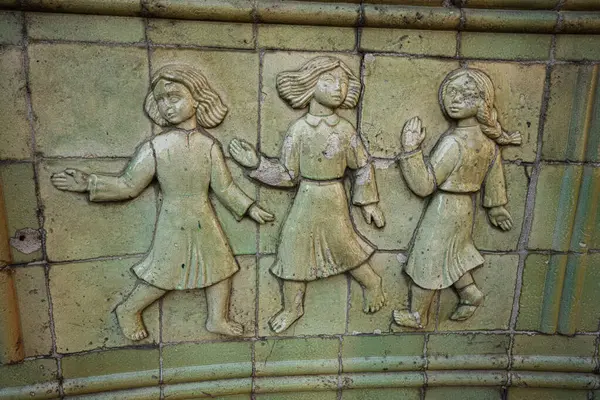 Lviv, Ukrayna - Nisan 06, 2025: Tarihi bir ortamda dekoratif bir fayansta üç figürün sanatsal tasviri