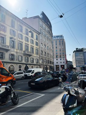 Milan, İtalya - 26 Mart 2025: Milano, İtalya 'da şehir caddesi açık gökyüzü altında trafik ve binalar