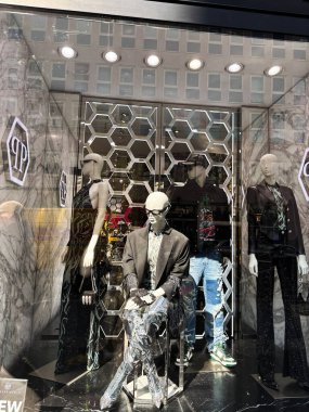 Milan, İtalya - 26 Mart 2025: Modeller şık dekorlu bir Milan mağazası Philipp Plein vitrininde lüks moda sergiliyor.