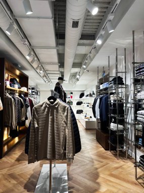 Milan, İtalya - 26 Mart 2025: Modaya uygun Tommy Hilfiger perakende mağazası iç mekan vitrinleri ve özenle düzenlenmiş aksesuarlar