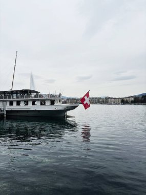 Cenevre, İsviçre - 27 Mart 2025: Bir tekne İsviçre 'nin Cenevre kentinde sakin göl sularına yanaştı