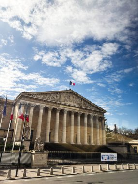 Paris, Fransa - 28 Mart 2025: Sütunları ve heykeli bulutlu gökyüzü altında tarihi Fransız hükümet binası.