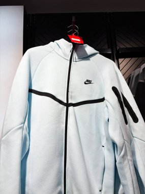 Paris, Fransa - 28 Mart 2025: Modern bir perakende mağazasında fermuarlı açık mavi Nike kapüşonu