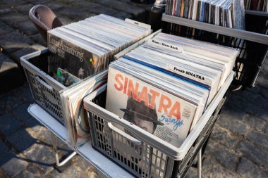 Lviv, Ukrayna - 07 Nisan 2025: Frank Sinatra ve Louis Armstrong plak koleksiyonu açık hava pazarında kasalarda sergilendi.