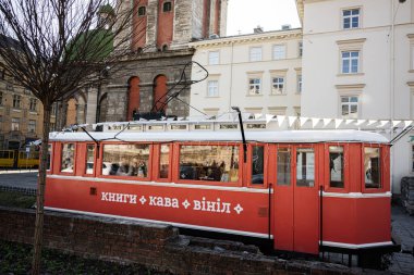 Lviv, Ukrayna - 07 Nisan 2025: Lviv 'de tarihi mimari ve kentsel cazibe ile çevrili kırmızı vintage tramvay kafe