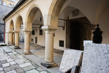 Lviv, Ukrayna - 07 Nisan 2025: Lviv 'de kolon kemerleri, taş eserleri ve kültür mirasının yer aldığı antik avlu. Mary 'nin Tahmini Ermeni Katedrali. 