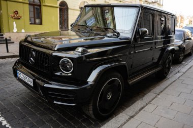 Lviv, Ukrayna - 07 Nisan 2025: Premium siyah Mercedes-Benz G 63 AMG SUV Ukrayna 'nın tarihi şehri Lviv' de bir sokağa park edildi