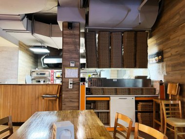 Kyiv, Ukrayna - 08 Nisan 2025: İstiflenmiş pizza kutuları, ahşap mobilyalar ve sıcak bir ortam içeren pizza restoranı içi