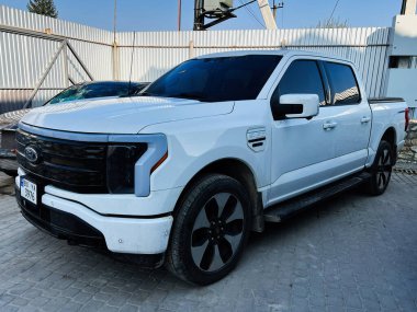 Kyiv, Ukrayna - 08 Nisan 2025: Beyaz kamyonet Ford F-150 Lightning metalik kaplama ve ekipman arka planına sahip açık gökyüzü altında sergilendi.