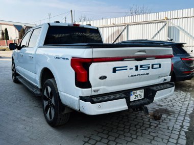 Kyiv, Ukrayna - 08 Nisan 2025: Açık havada park edilmiş beyaz bir Ford F-150 Lightning elektrikli kamyonun arka görüntüsü