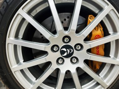Kyiv, Ukrayna - 08 Nisan 2025: Bir arabanın gümüş alaşımlı tekerleği ve altın fren ayarlı Brembo 'nun detaylı çekimi