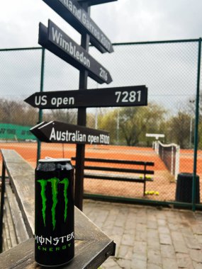 Kyiv, Ukrayna - 08 Nisan 2025: Enerji Canavarının yakın plan içeceği tenis kortunun yanında turnuva işaretleri görünür