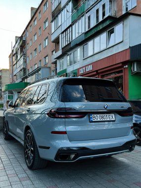 Kyiv, Ukrayna - 08 Nisan 2025: Modern lüks BMW X7 SUV kentsel bir yerleşim alanının dışında park edilmiş