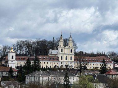 Buchach, Ukrayna - 08 Nisan 2025: Bulutlu bir günde kırsal bir mahallede bulunan bir Hıristiyan manastırı. Buchach Manastırı. Basilian Babalarının Kutsal Haçı 'nın Yüceliği.