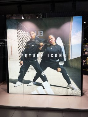Kyiv, Ukrayna - 08 Nisan 2025: Spor giysileri içinde iki kişinin yer aldığı moda eğilimlerinin dinamik Adidas temsili