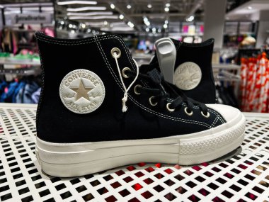 Kyiv, Ukrayna - 08 Nisan 2025: Modern bir perakende mağazasında yıldız logosu sergilenen klasik siyah Converse All Star spor ayakkabıları.