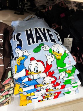 Kyiv, Ukrayna - 08 Nisan 2025: Bir mağaza rafında parlak Donald Duck çizgi film karakterleriyle dolu istiflenmiş tişörtler