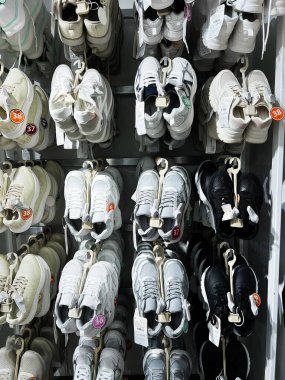 Kyiv, Ukrayna - 08 Nisan 2025: Bir mağaza vitrininde boyut işaretleri bulunan çeşitli spor ayakkabıları içeren düzenli raflar.