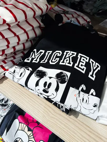 Kyiv, Ukrayna - 08 Nisan 2025: Popüler Mickey Mouse karakterinin tasarımlarının yer aldığı siyah ve beyaz grafik tişörtlerinin yakın görüntüsü