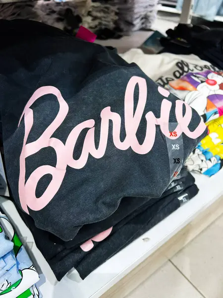 Kyiv, Ukrayna - 08 Nisan 2025: Düzenli katlanmış Barbie tasarımları raflarda sergilenen bir dizi tişört.