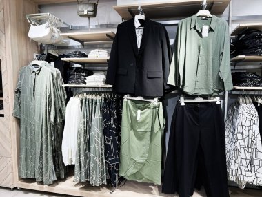 Kyiv, Ukrayna - 08 Nisan 2025: Şık geometrik tasarımlı yeşil ve siyah elbiseler sergilenen moda giyim mağazası