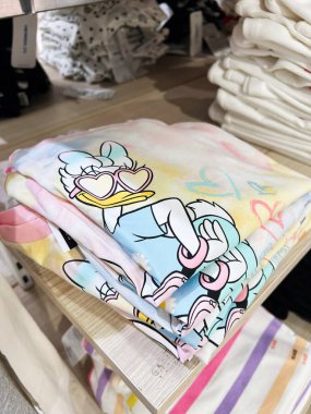 Kyiv, Ukrayna - 08 Nisan 2025: Renkli ve canlı baskılı tasarım gösteren Daisy Duck tişörtleri