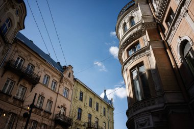 Lviv, Ukrayna 'da açık mavi gökyüzü altında güneş ışığıyla aydınlatılan Avrupa mimari binaları.