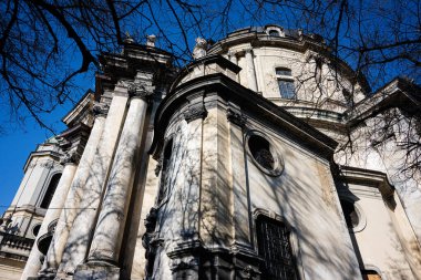 Lviv 'deki Dominik Kilisesi' nin Barok mimari cephesi mavi gökyüzünün altında tarihi bir cazibe sergiliyor.
