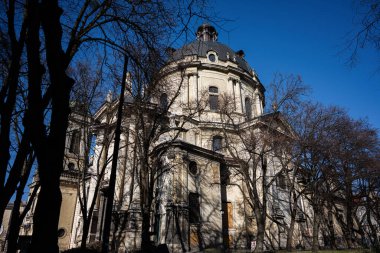 Dominik Kilisesi ve Manastırı 'nın tarihi bir binası. Etrafı ağaçlarla çevrili, canlı mavi gökyüzüne karşı ele geçirilmiş..