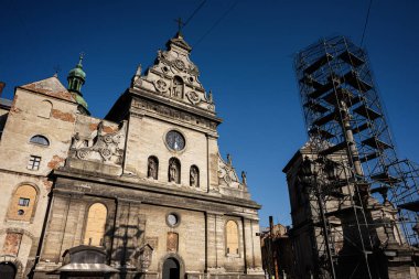 İkonik Bernardine kilisesi ve Lviv 'deki iskeleli manastır cephesi mavi gökyüzüne karşı güneş ışığında yıkandı. St. Andrew, St. Andrew Tarikatı. Ukrayna Katolik Kilisesi 'nin Büyük Basil' i