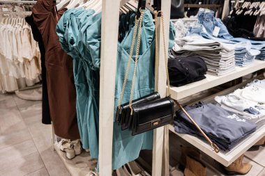 Moda elbiseler, aksesuarlar ve katlanmış kıyafetler perakende mağazasında sergileniyor..
