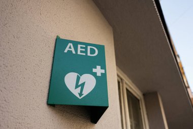 Bina duvarında yeşil AED defibrilatör işareti var. Acil tıbbi malzeme konumu gösteriliyor..