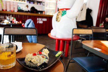 Modern bir Japon restoranında soslu ve içkili lezzetli suşi tabağı