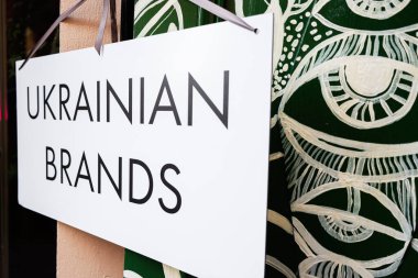 Arkaplanda sanatsal grafiklerle Ukrayna markalarının yer aldığı bir işaret