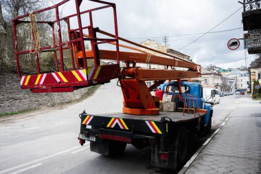 Buchach, Ukrayna - 08 Nisan 2025: Turuncu hava aracı Buchach, Ukrayna 'da bir caddeye park edilmiş, binaların yakınına..