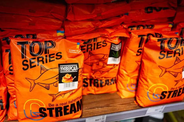 Kyiv, Ukrayna - 14 Nisan 2025: Balık yemi ürünlerinin turuncu paketleri bir mağaza rafında düzenlendi