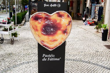 Fatima, Portekiz - 15 Nisan 2025: Portekiz 'in Fatima şehrinin büyüleyici caddesinde kalp şeklinde pasta tabelası sergilendi