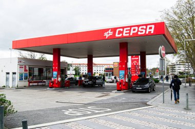 Fatima, Portekiz - 15 Nisan 2025 Fatma, Portekiz 'deki Cepsa benzin istasyonu, bulutlu bir gökyüzü altında yakıt ikmali yapan araçlar.