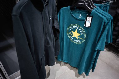 Khmelnytskyi, Ukrayna - 16 Nisan 2025: Converse perakende mağazasında giysi tişörtü sergileniyor, tasarım ve giysi düzenlemesi vurgulanıyor.