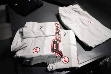 Khmelnytskyi, Ukrayna - 16 Nisan 2025: Beyaz katlanmış Puma spor giyim, ceket ve pantolon dahil, koyu bir masa üstü yüzeyi üzerinde sergilenmektedir