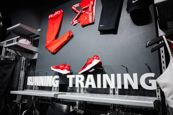 Khmelnytskyi, Ukrayna - 16 Nisan 2025: Açık kırmızı ve siyah Nike Pro spor kıyafetleri spor mağazasında sergilenen ayakkabılar.