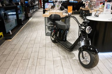 Khmelnytskyi, Ukrayna - 16 Nisan 2025: Bir perakende elektronik mağazasında diğer cihazlarla birlikte sergilenen siyah elektrikli Maxxter scooter.