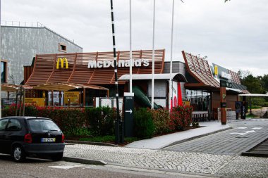 Fatima, Portekiz - 15 Nisan 2025: Fatima, Portekiz 'de çağdaş McDonald' s cepheleri, bir MCdrive ve açık hava koltukları.