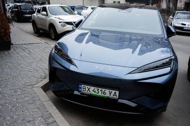 Khmelnytskyi, Ukrayna - 16 Nisan 2025: Mavi BYD Deniz Aslanı 07 elektrikli araç kaldırım taşı caddesinde park halinde, diğer arabalarla çevrili.